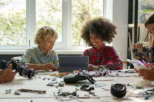 Children together at a table engineering.